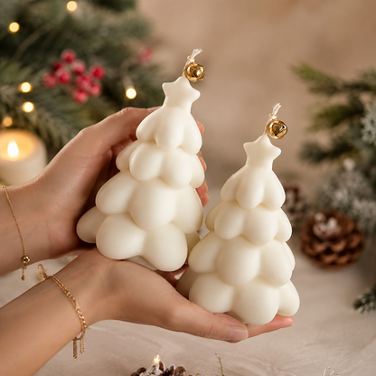 Snowtree luxury ivory handmade soy wax Christmas tree candle set with gold bell detail displayed on natural travertine in a luxury festive studio setting.