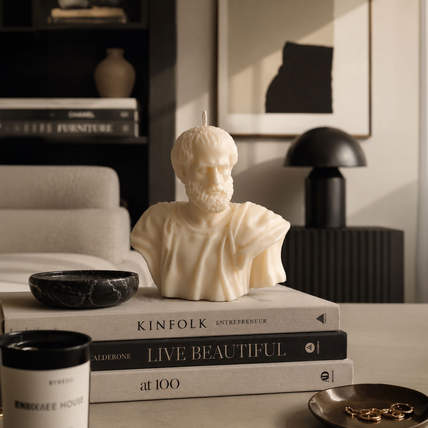 Aristotle Bust Candle displayed on coffee table books in a modern luxury interior, artisan Greek philosopher candle by Warm Warren London.