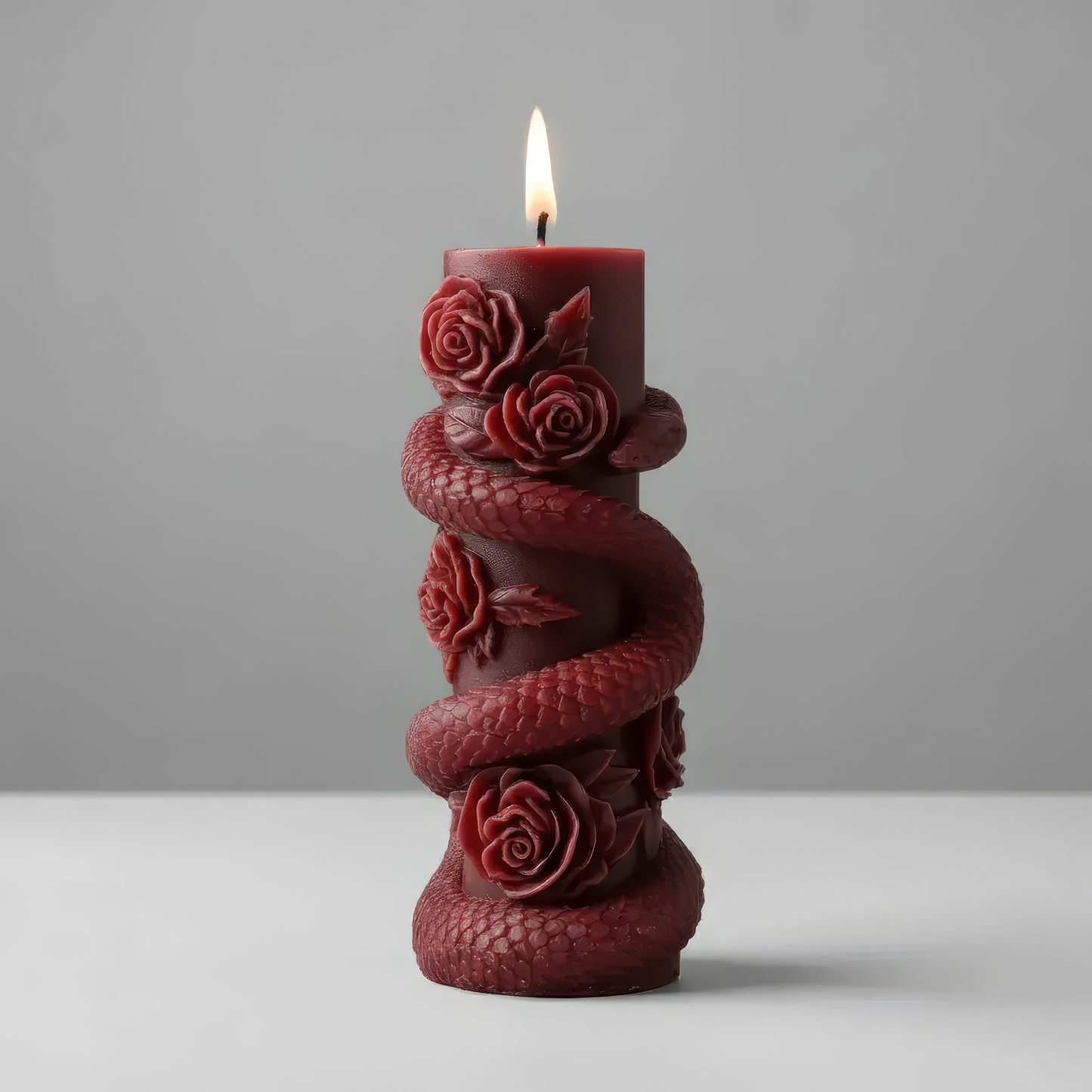 snake-shaped candle with roses on a light gray background. Venom Rose Pillar - Gothic Collection Soy Wax Handmade Candle Halloween