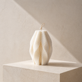 Ivory Cocoon Pillar Candle with layered ribbed folds on a limestone pedestal in natural sunlight. Warm Warren London, ivory vegan handmade soy wax decorative candle