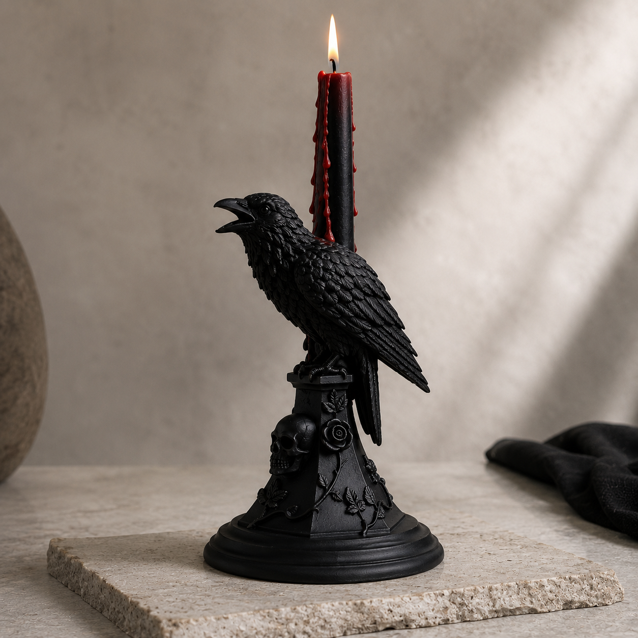 Two handmade black raven candle holders with skull bases displayed on a minimalist Halloween dining table, styled with black bleeding taper candles and gothic décor.