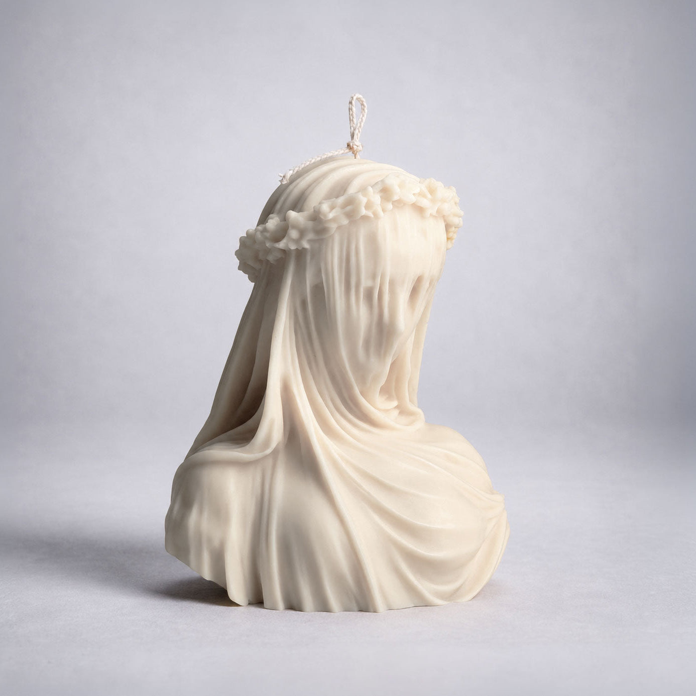 Veiled Vestal handmade sculptural candle inspired by classical art, large ivory sculpture candle with floral crown and flowing drapery, luxury home decor. Warm Warren London