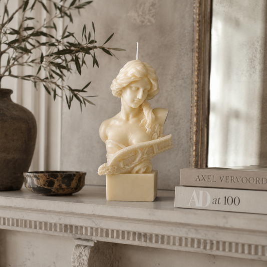 Lyra Sculpture Candle handcrafted ivory wax bust featuring a classical female sculpture holding a lyre, photographed on a premium neutral studio background.